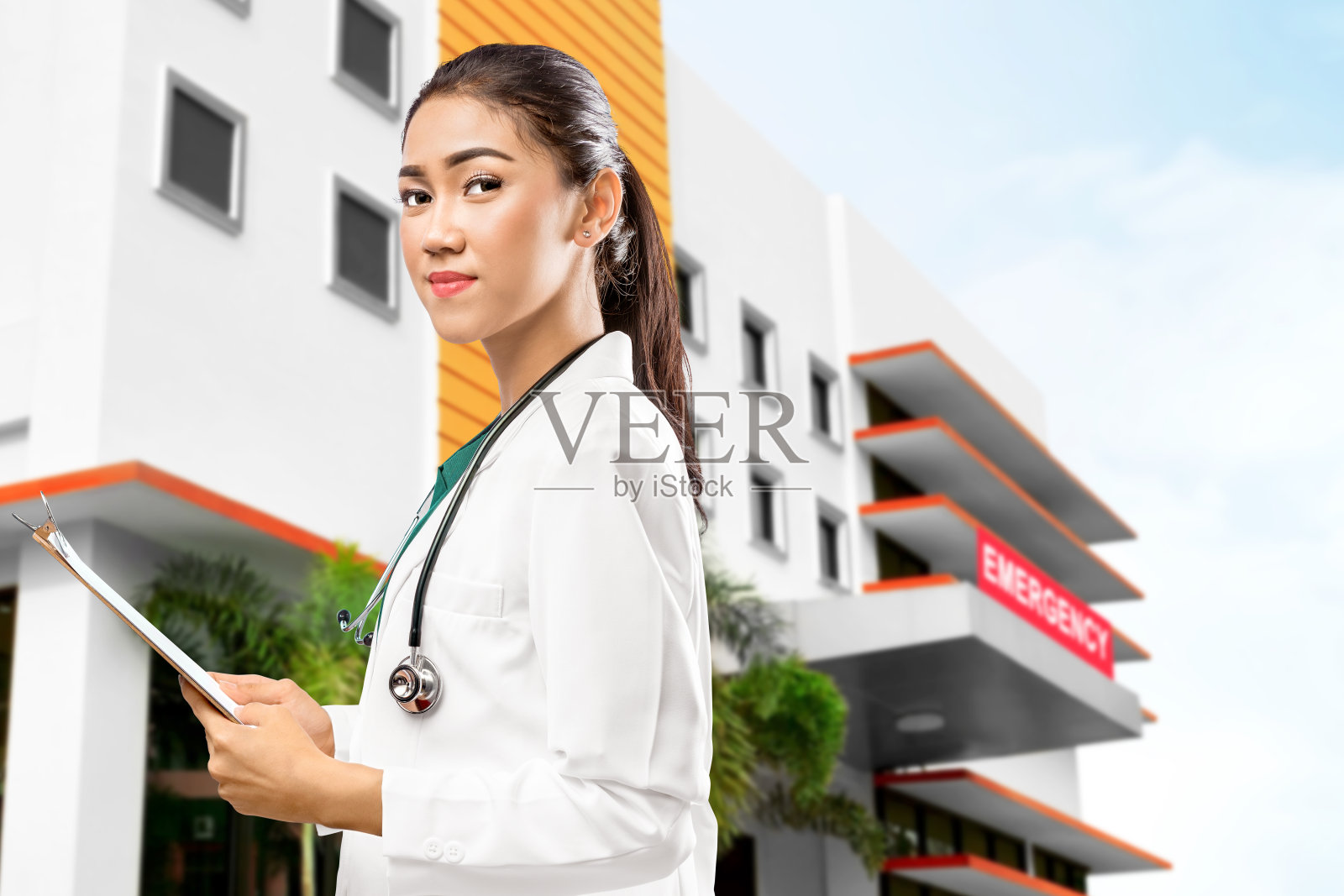 亚洲女医生拿着听诊器在急救室前拿着写字板照片摄影图片