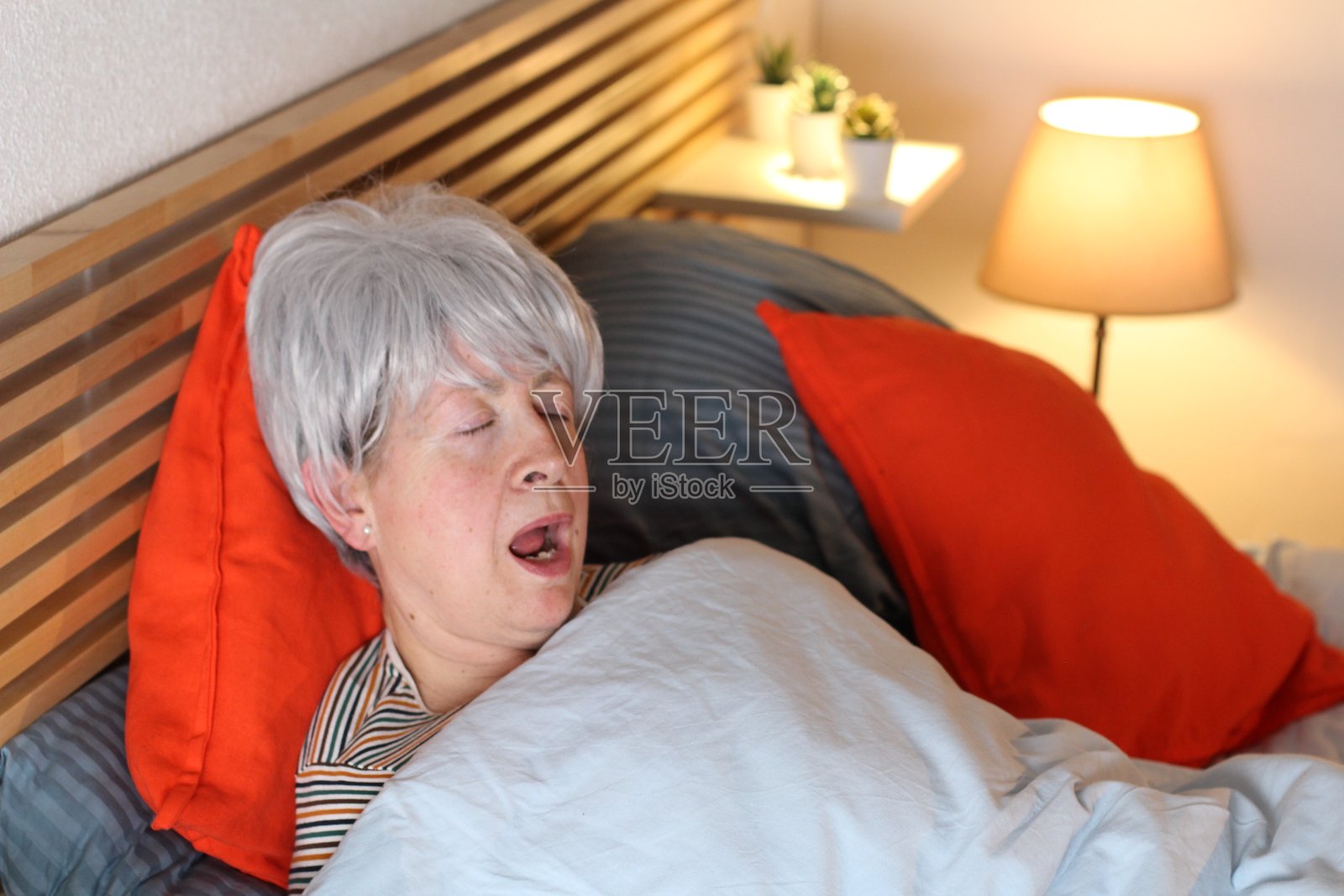 老女人在床上打鼾照片摄影图片