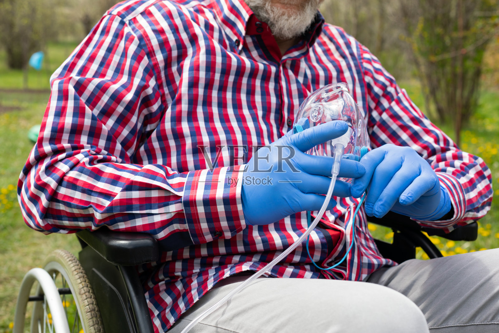 戴着面具坐在轮椅上的老人照片摄影图片