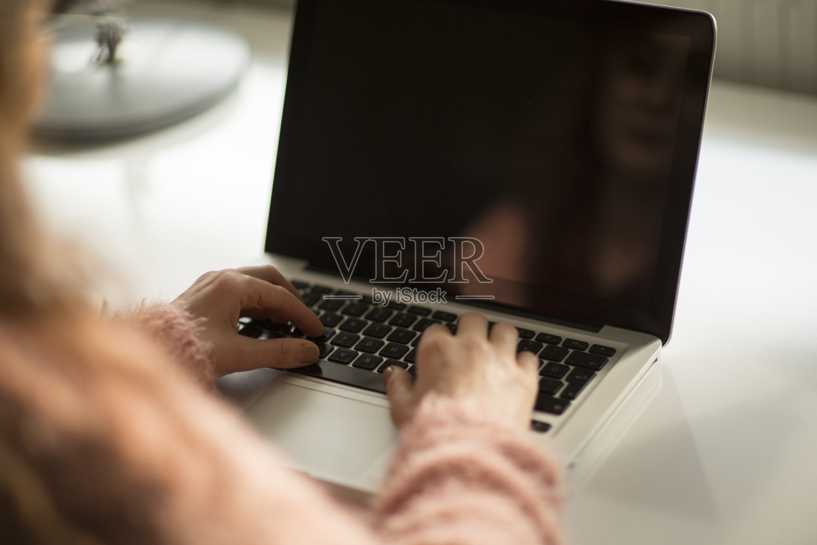 一个女人的手在笔记本电脑上忙着打字的特写照片摄影图片