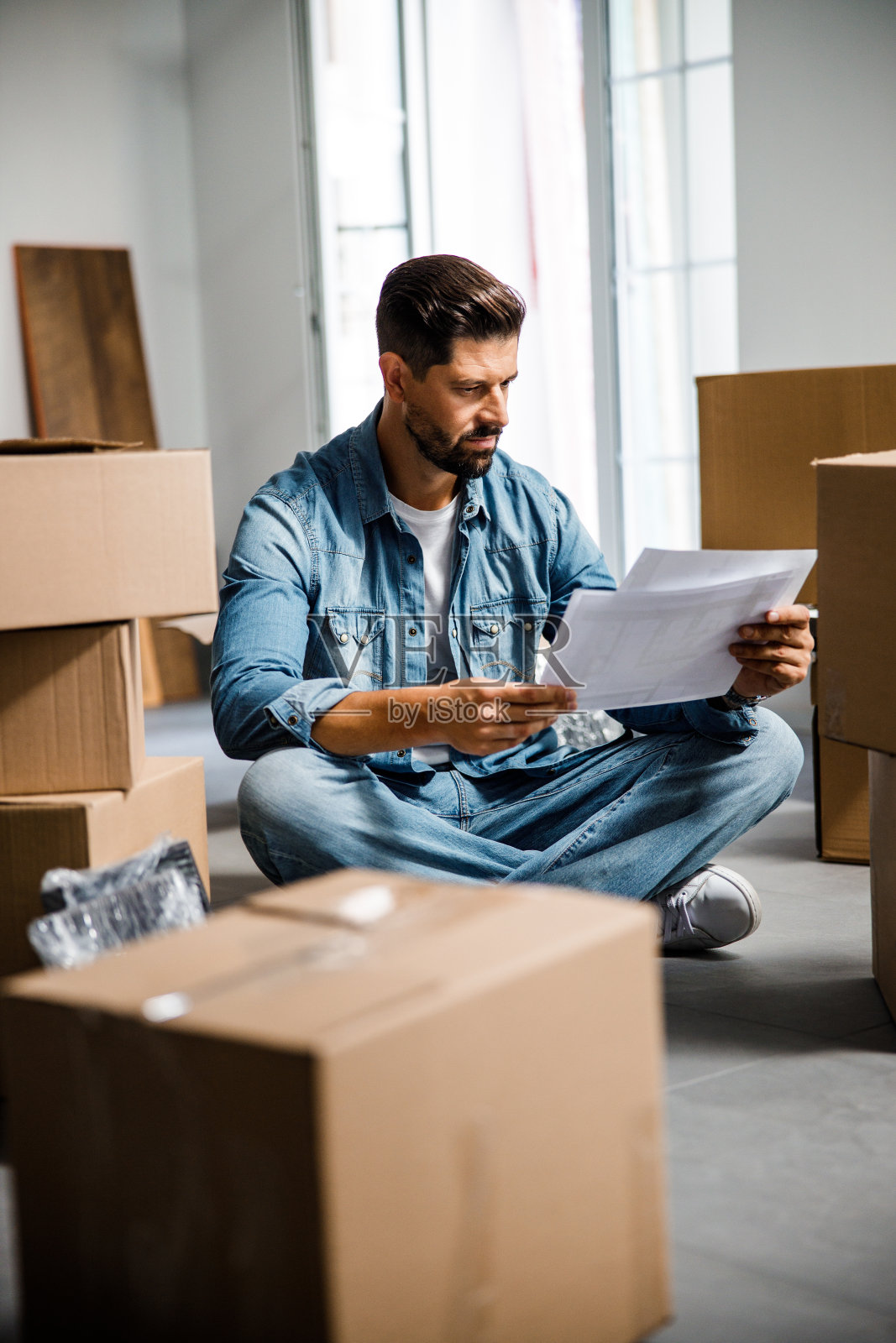 年轻有魅力的男子正在研究新公寓的计划照片摄影图片