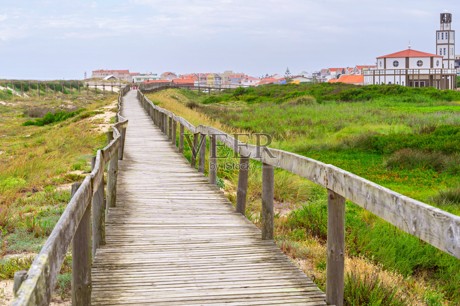 沙丘上的木路。葡萄牙阿威罗的新星海滩的木制人行桥。照片摄影图片