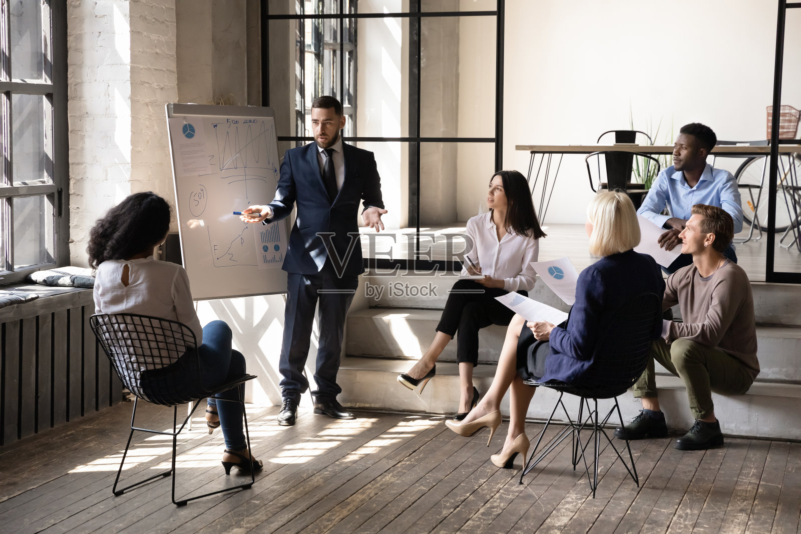 自信的商人导师在会议上展示挂图上的统计数据照片摄影图片