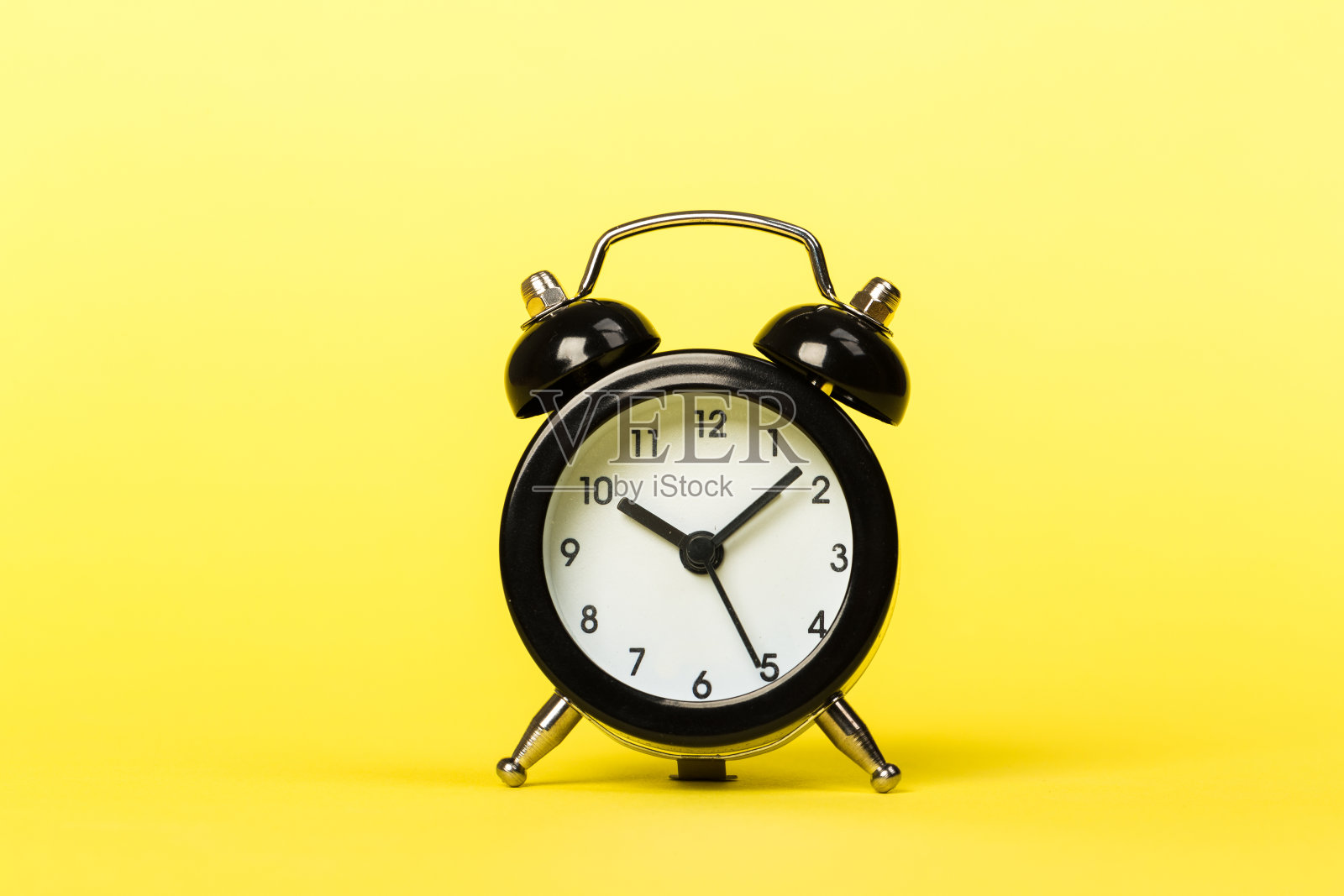 黄色背景上的黑色复古闹钟，时间概念，日常生活。十小时十分钟照片摄影图片