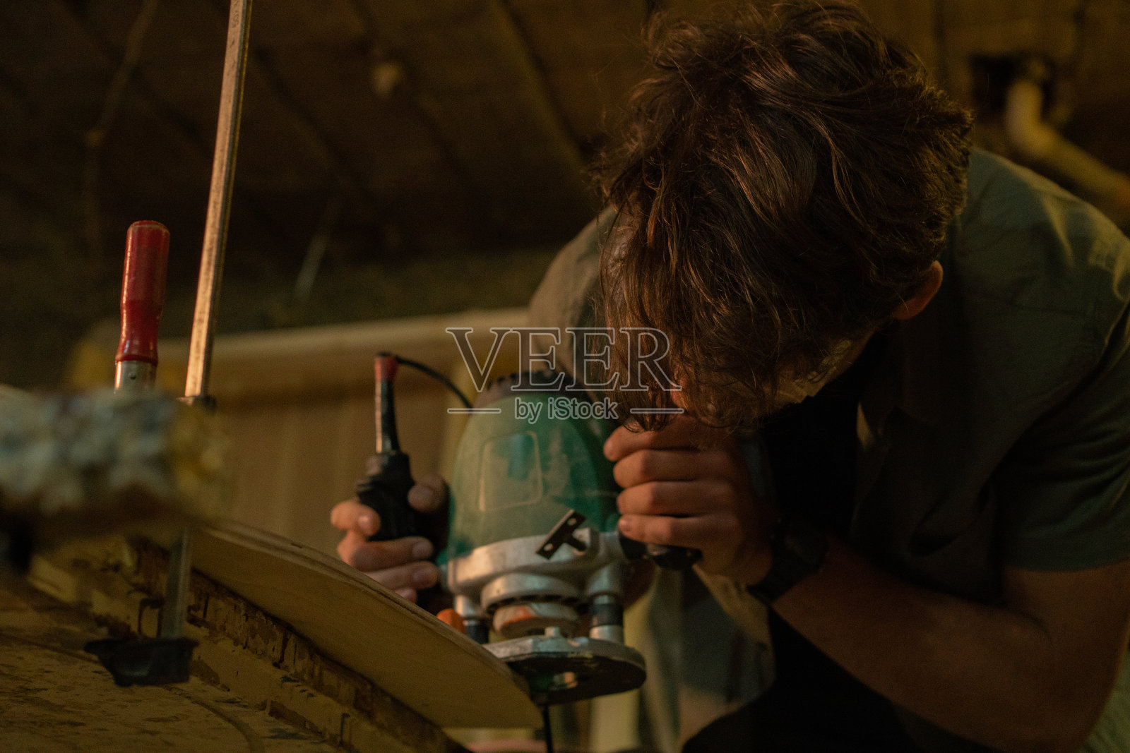 用工具磨平滑板边缘的木匠照片摄影图片