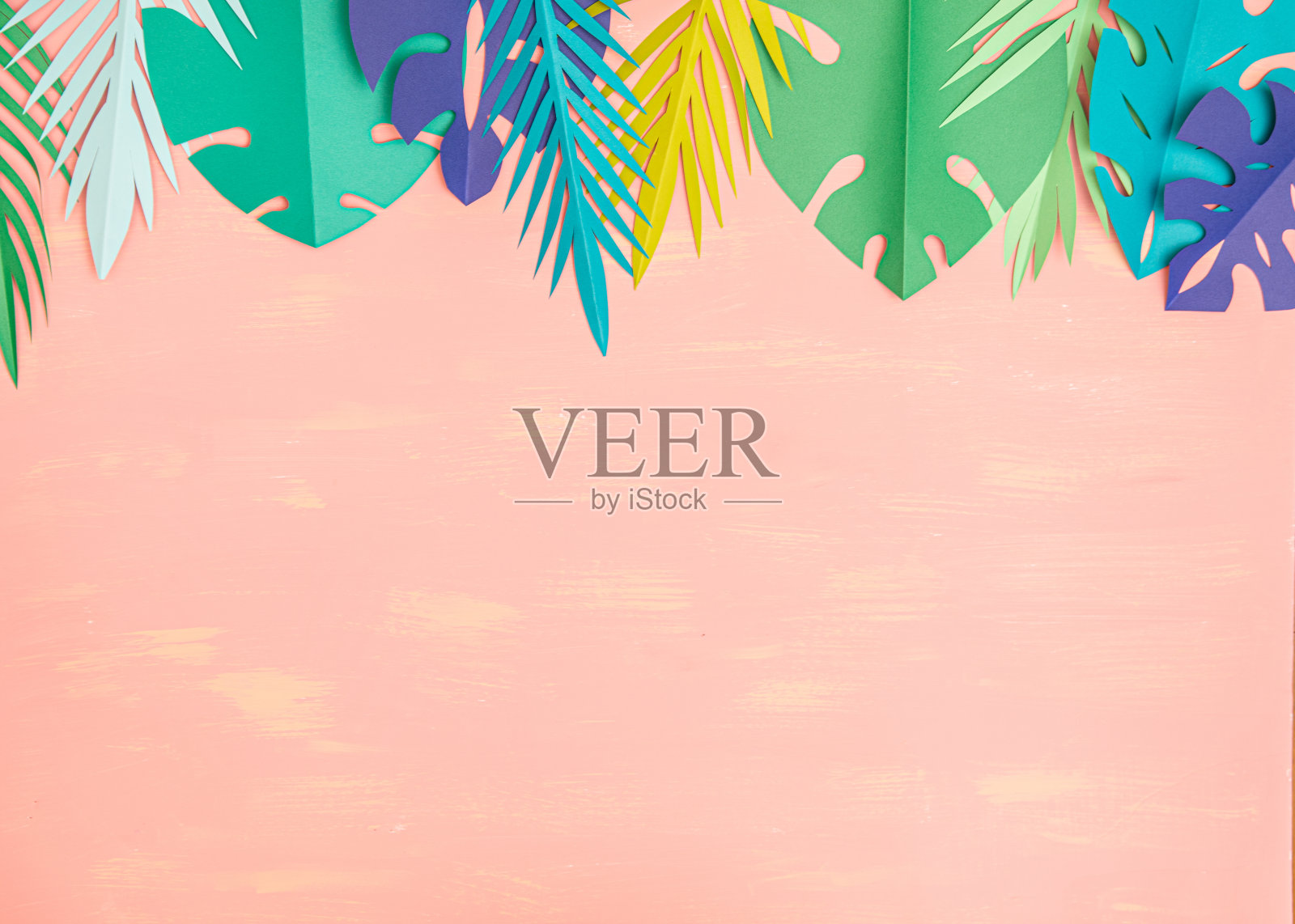 粉红色背景上的纸质热带树叶照片摄影图片