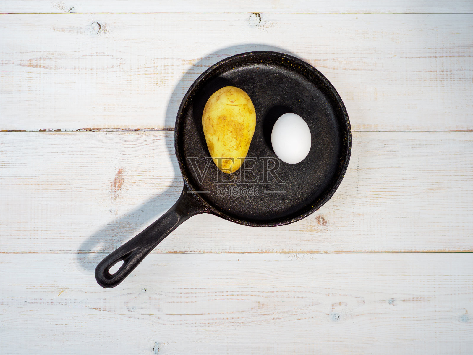 用铸铁平底锅煎土豆蛋。照片摄影图片