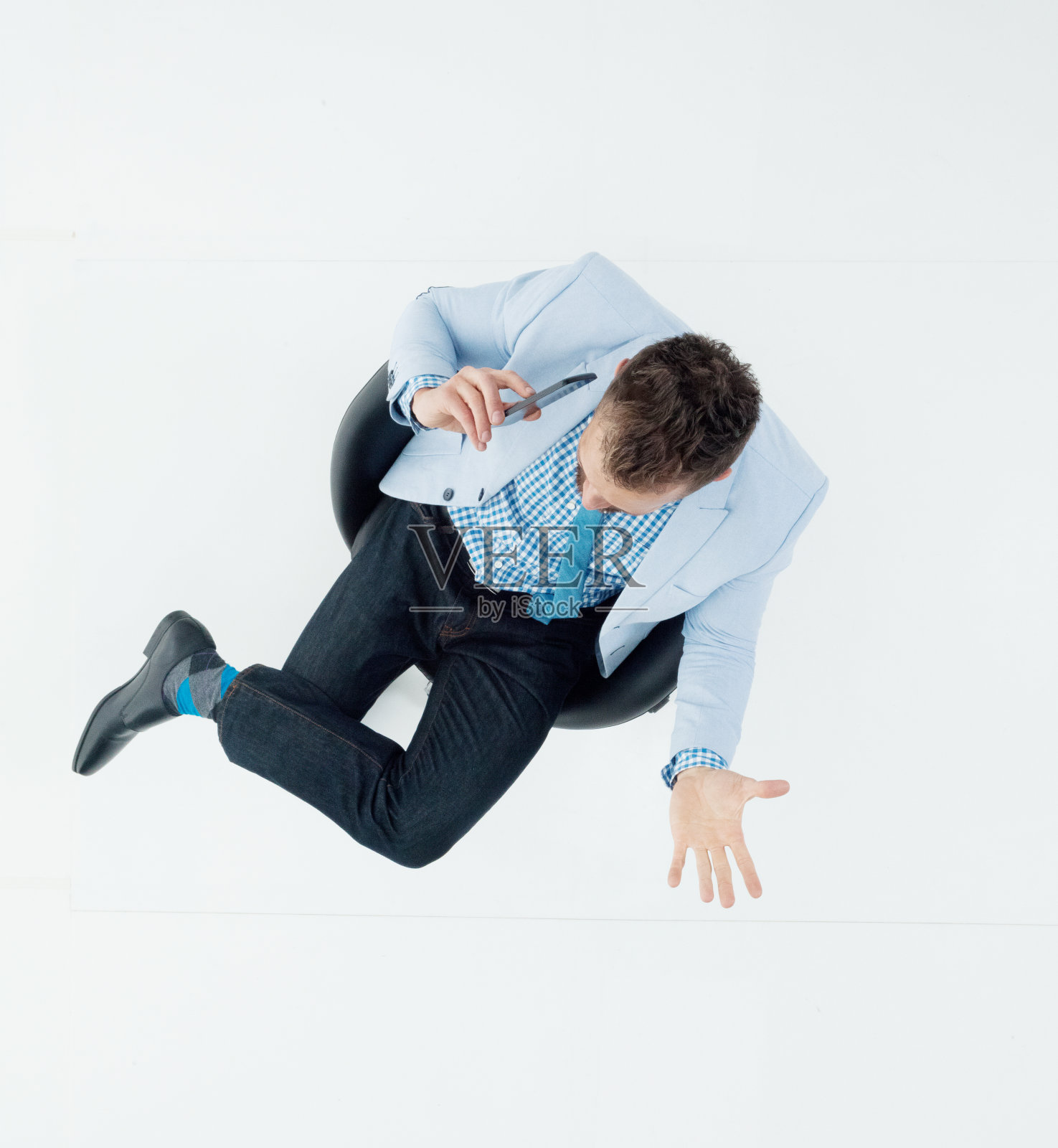 白人年轻男性经理穿着运动夹克，在白色背景前休息，使用智能手机照片摄影图片