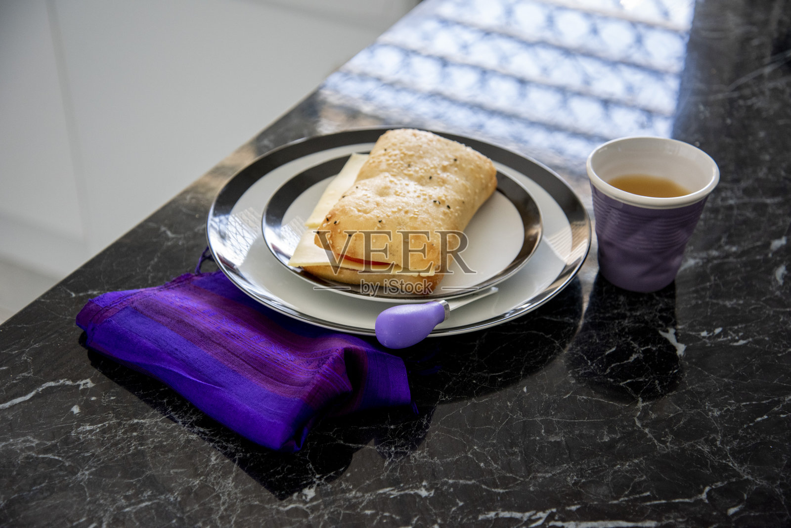 夏巴塔三明治，紫色餐巾和刀。照片摄影图片