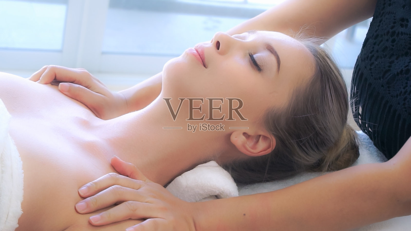 女人得到肩部按摩水疗治疗师。照片摄影图片