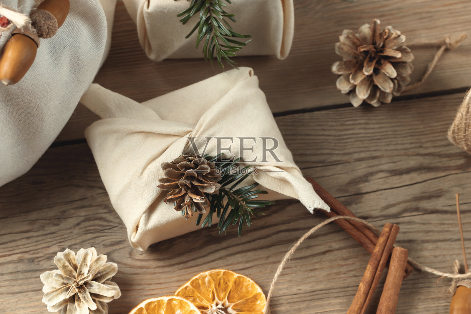 零浪费圣诞理念。包装在天然织物礼品和装饰从天然材料的木制桌子上，俯视图照片摄影图片