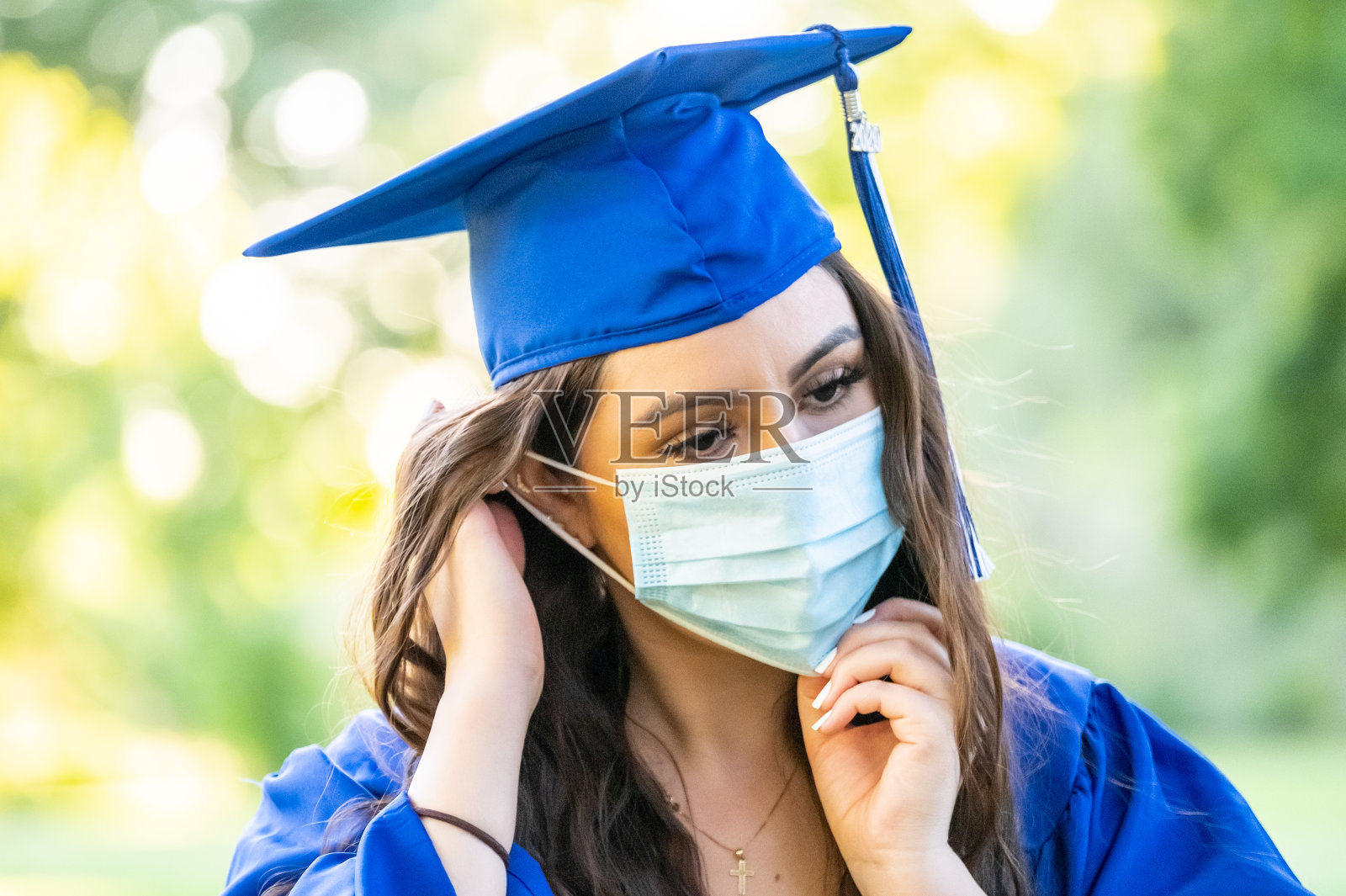 一名年轻女子戴着防护面具庆祝毕业照片摄影图片