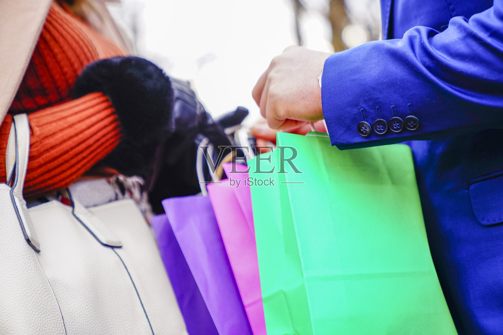 在城市里拿着购物袋的夫妇的腹部照片摄影图片