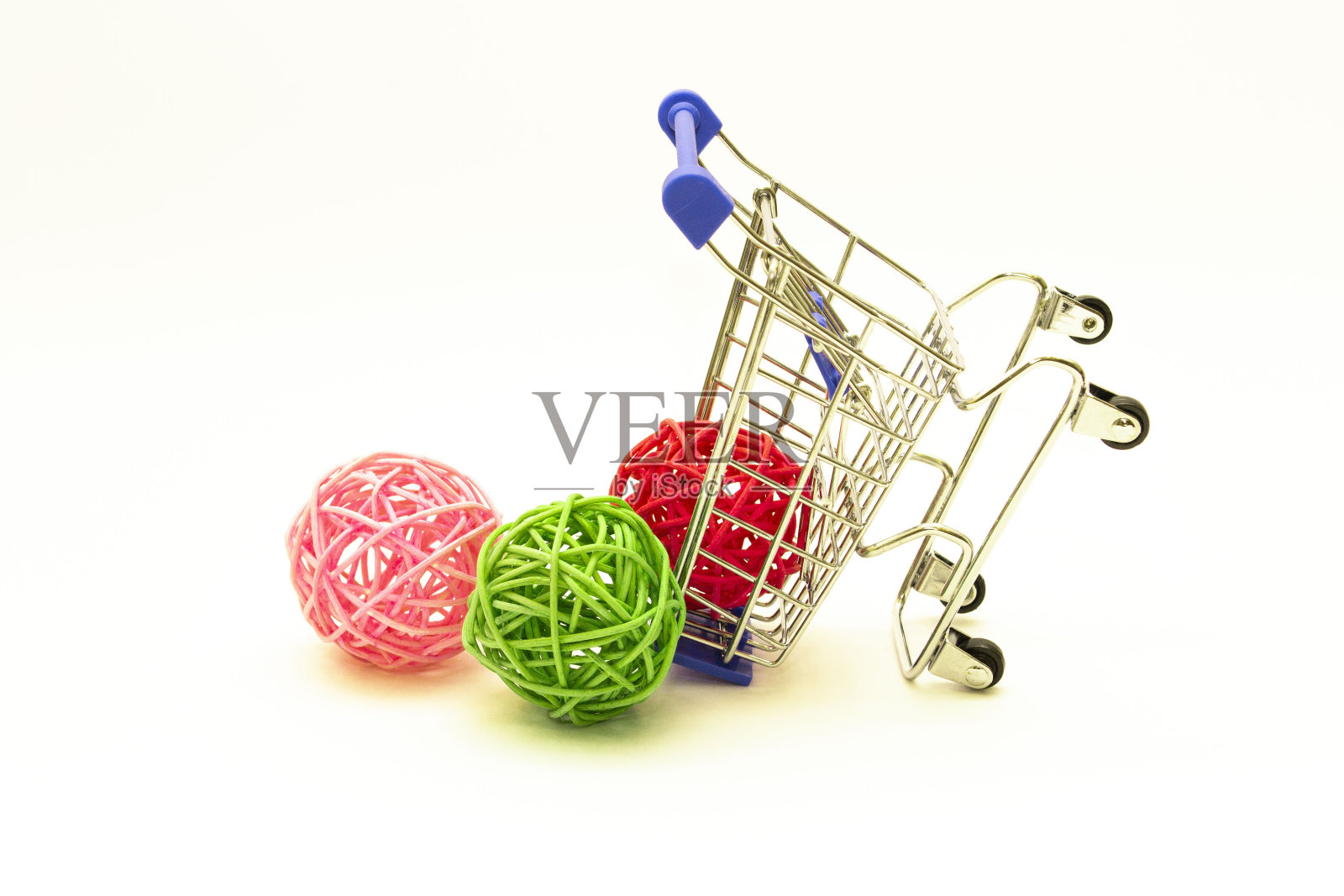 一辆购物车被五颜六色的藤球绊倒了。照片摄影图片