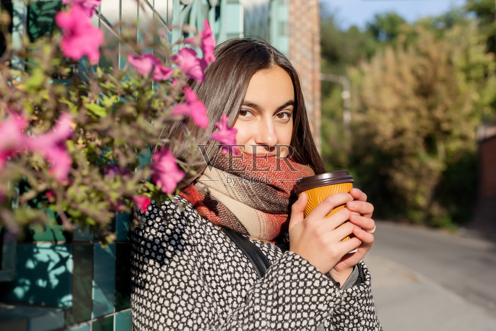 喝着咖啡走在城市的大街上照片摄影图片