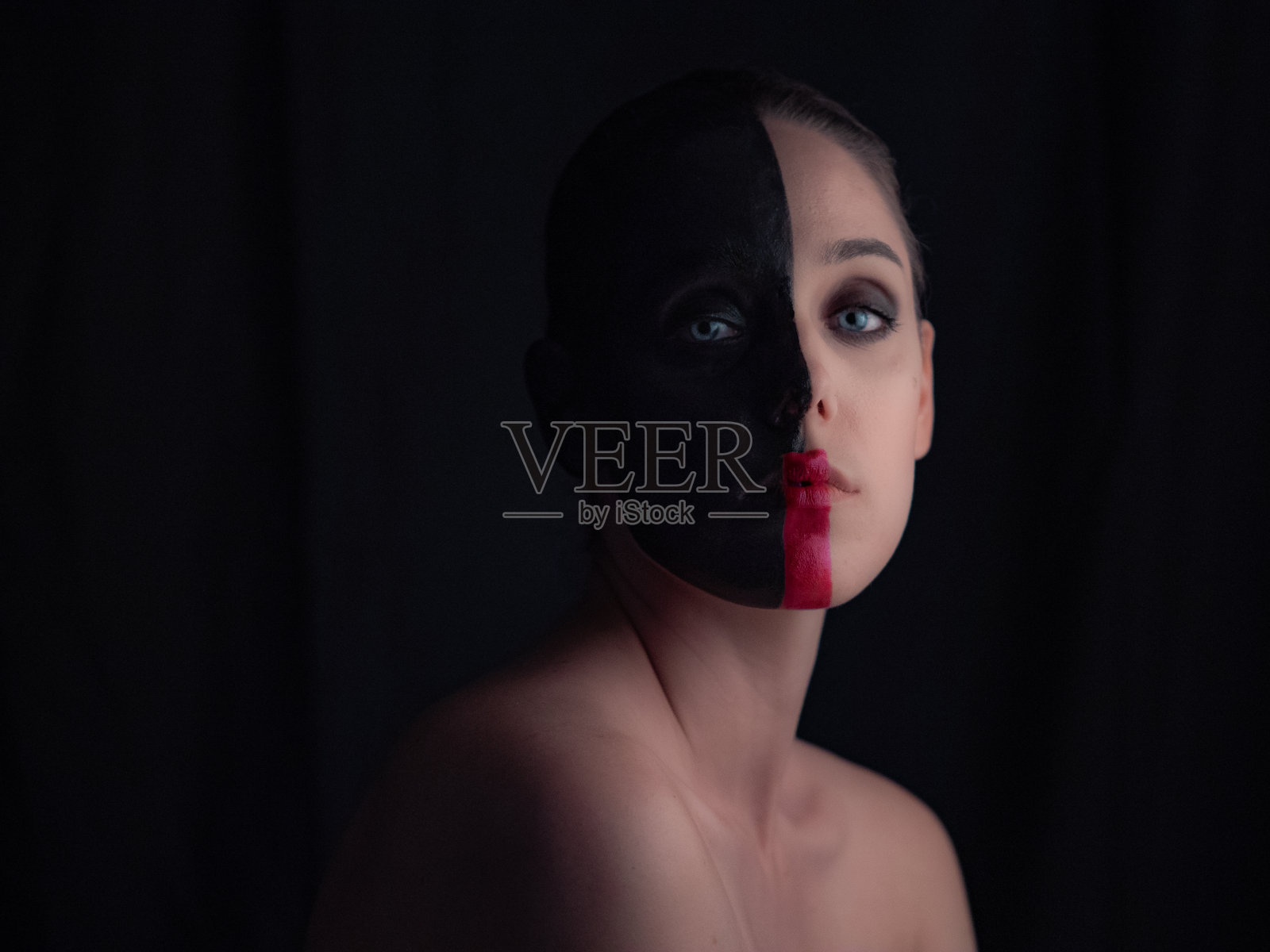 蓝眼睛女人半张脸涂黑照片摄影图片