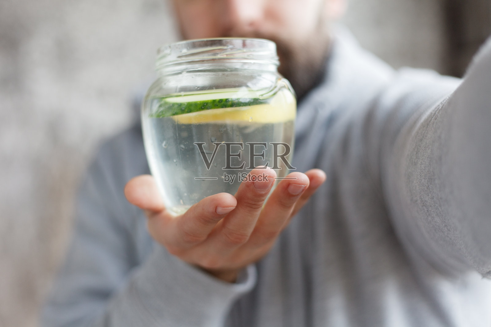 一个戴兜帽的男人在喝水的慢镜头照片摄影图片