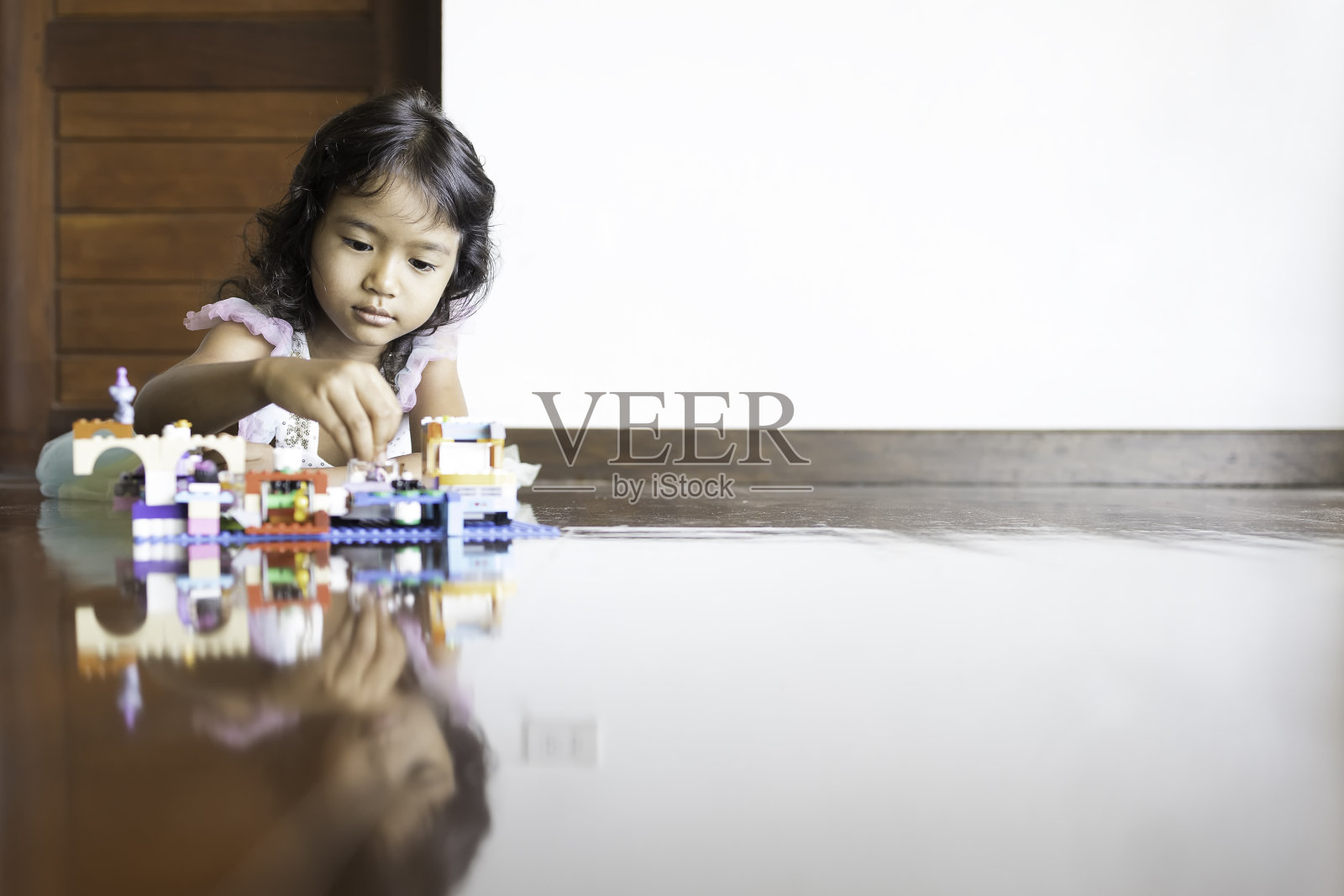 一个可爱的亚洲幼儿园女学生正在玩一个塑料拼图照片摄影图片