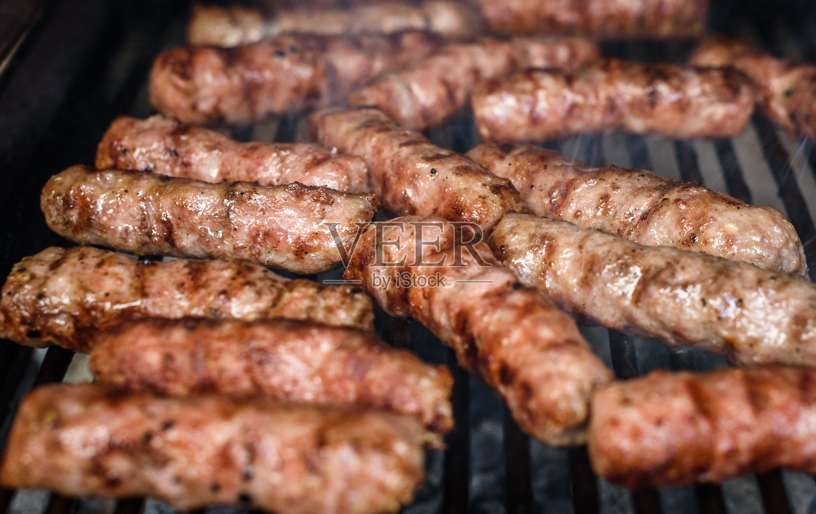 用热煤在烧烤架上烤肉。照片摄影图片