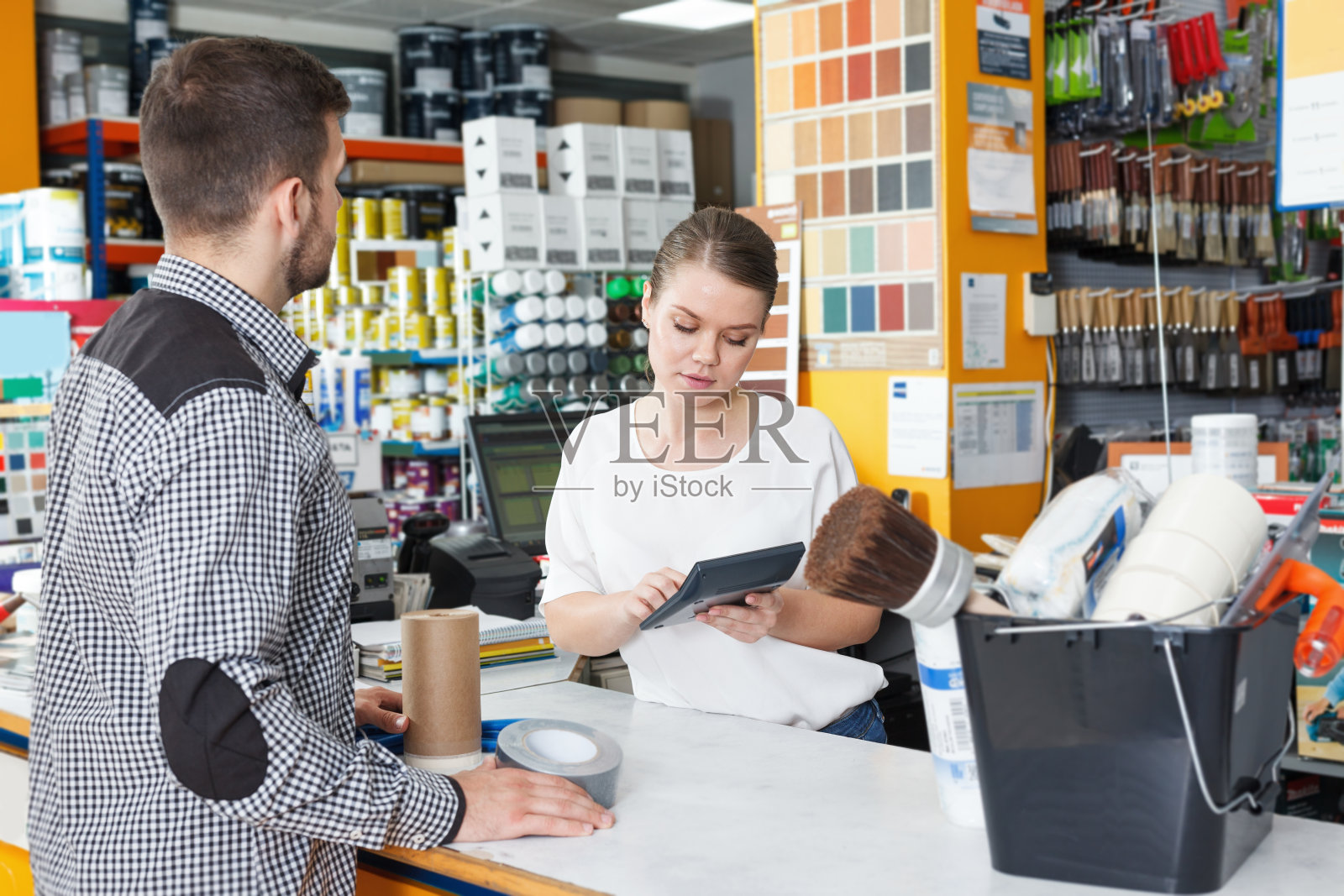 女售货员站在商店的柜台边帮助男售货员照片摄影图片