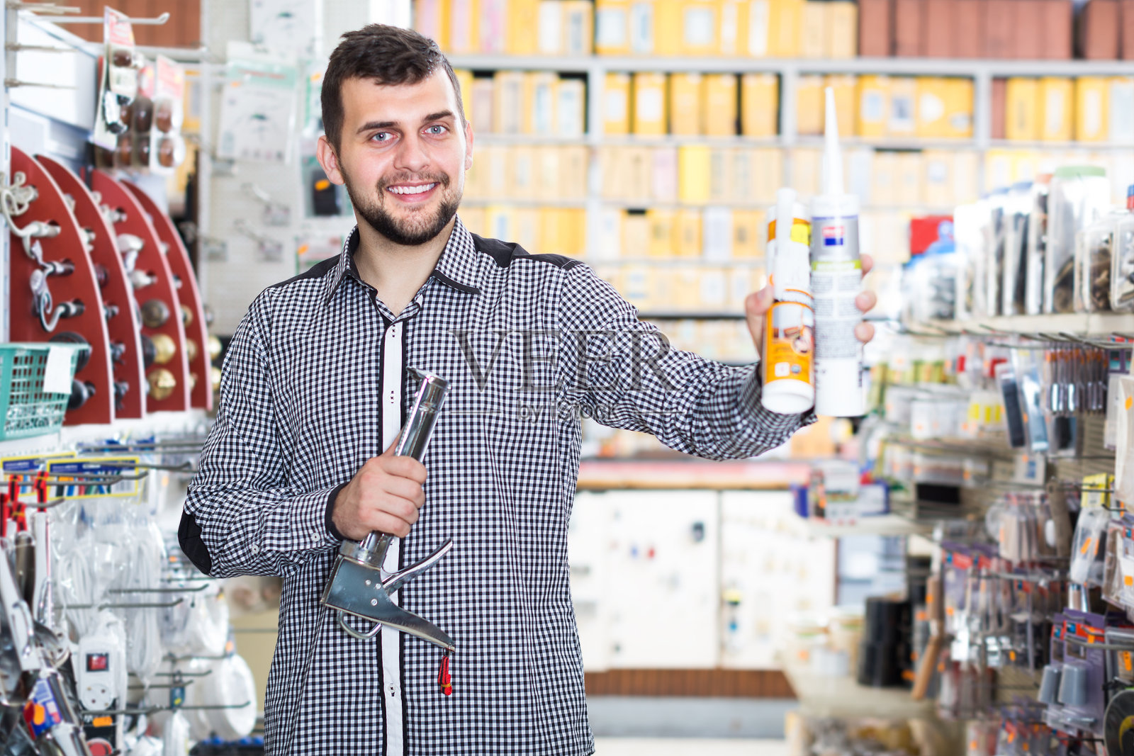 满意的男顾客在店里检查各种胶管照片摄影图片