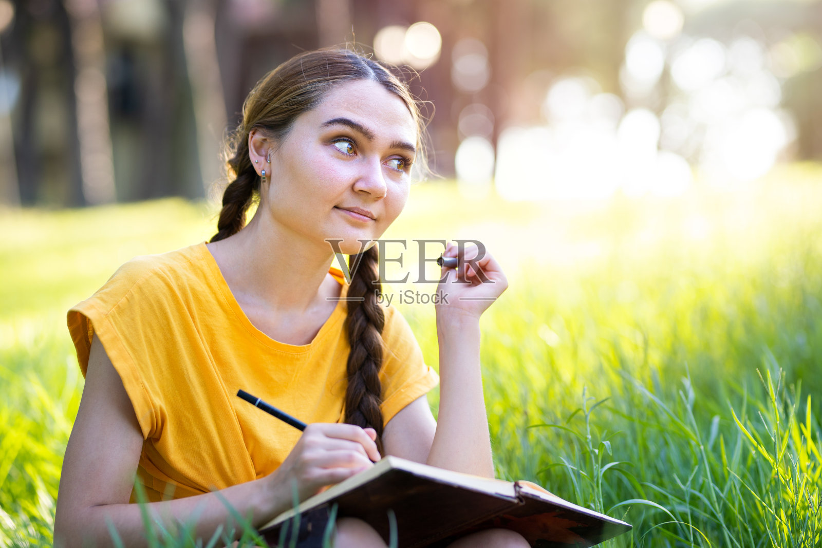 一个想在笔记本上写点东西的年轻女孩照片摄影图片