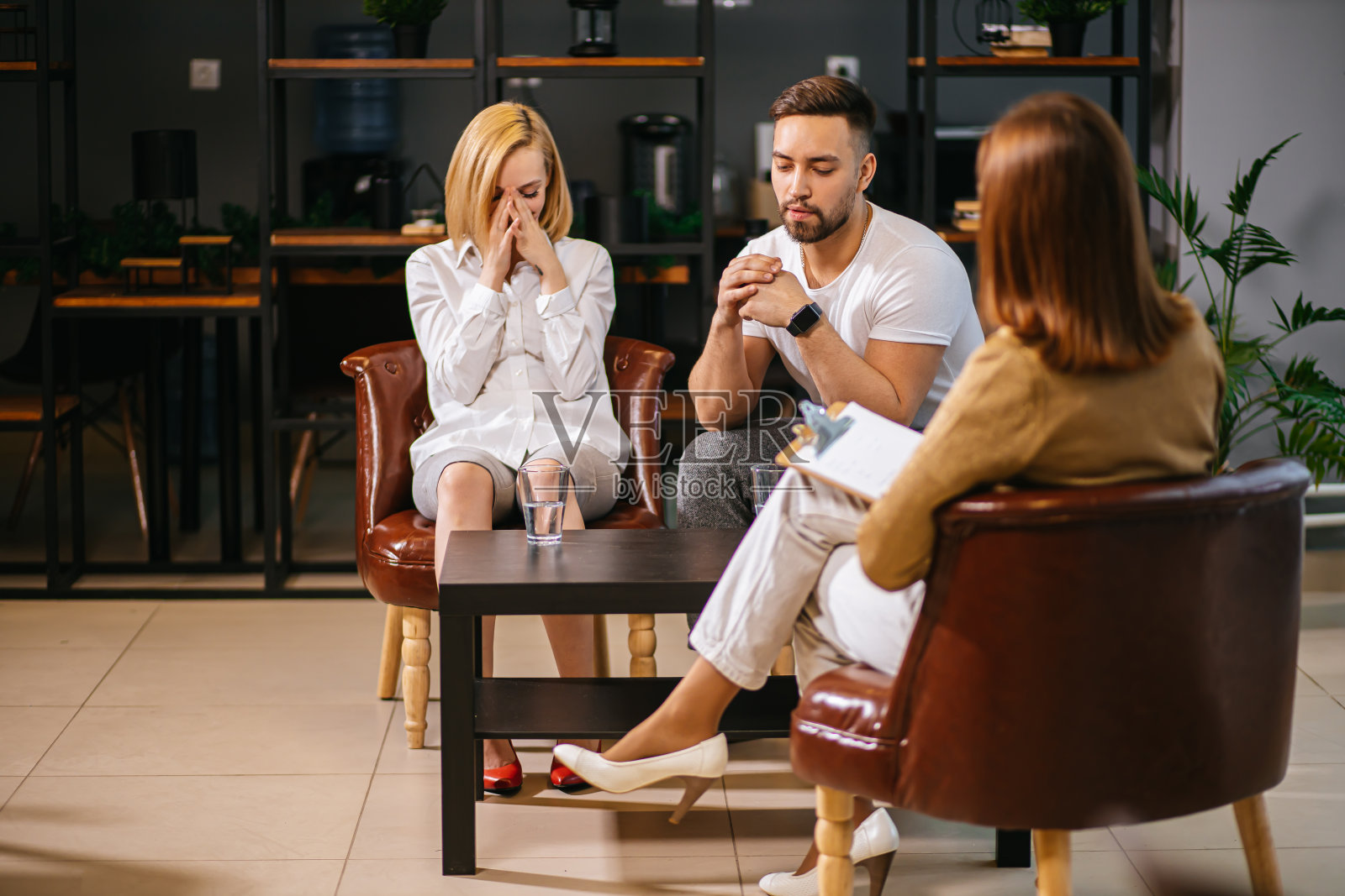 家庭分歧。年轻夫妇在婚姻治疗中与心理医生讨论他们的问题照片摄影图片