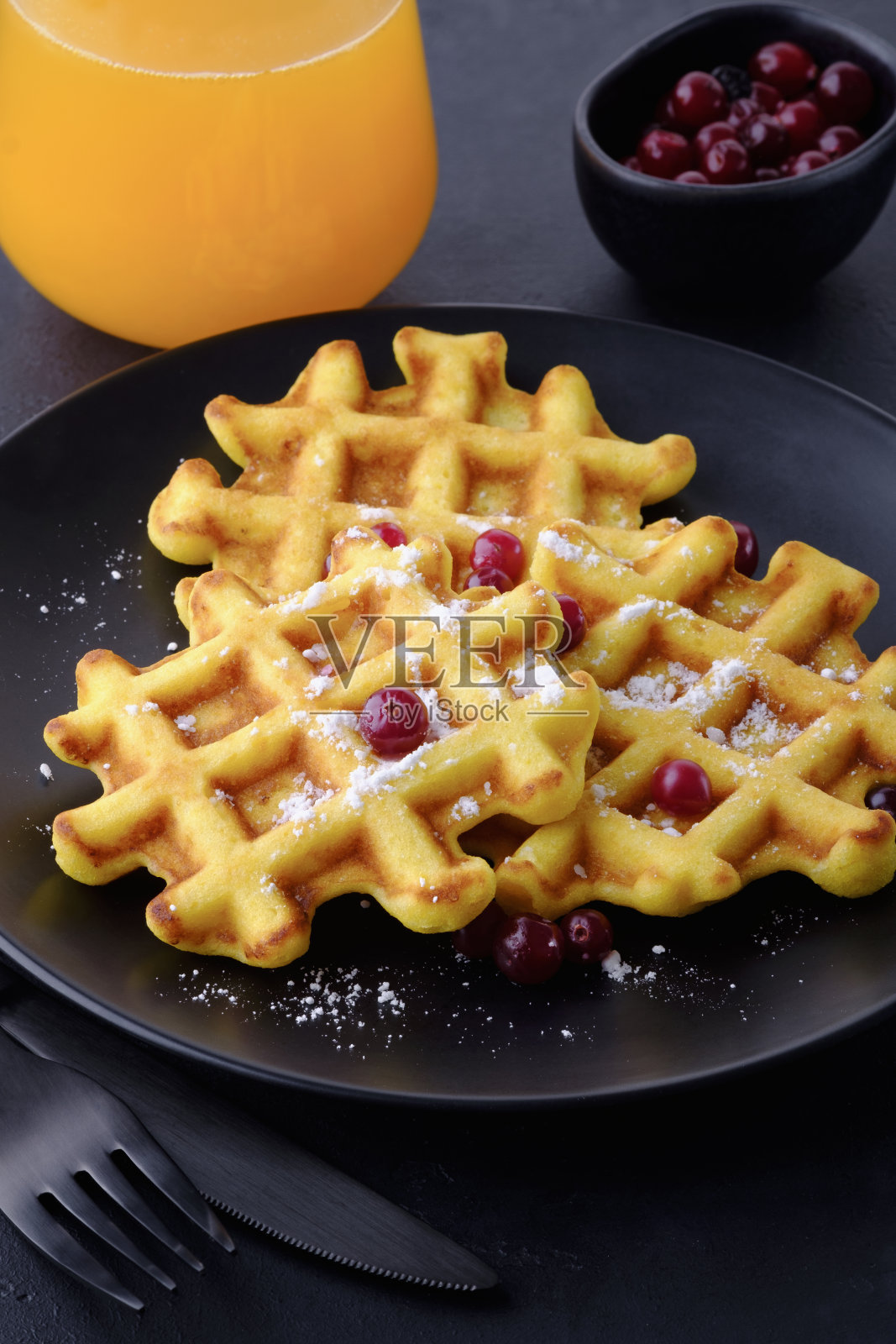 美味的自制比利时华夫饼配上蔓越莓和橙汁照片摄影图片