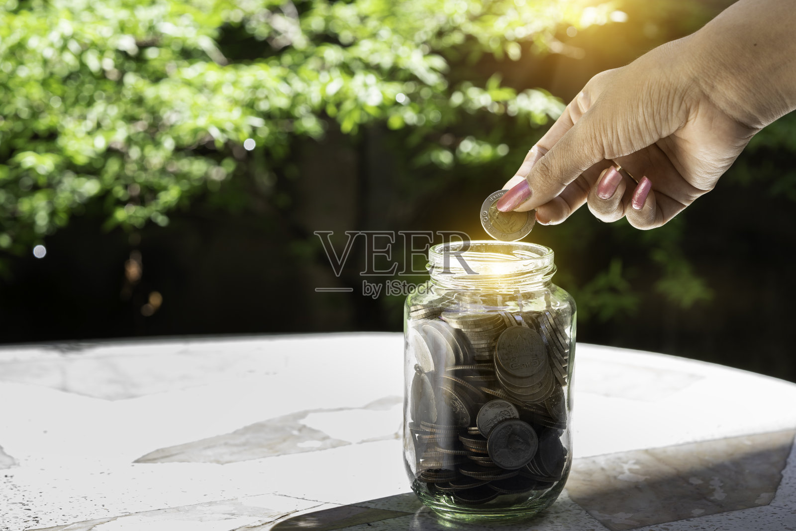 在玻璃罐中种植储蓄硬币，商业金融银行储蓄利息理念。投资的利润收入。照片摄影图片