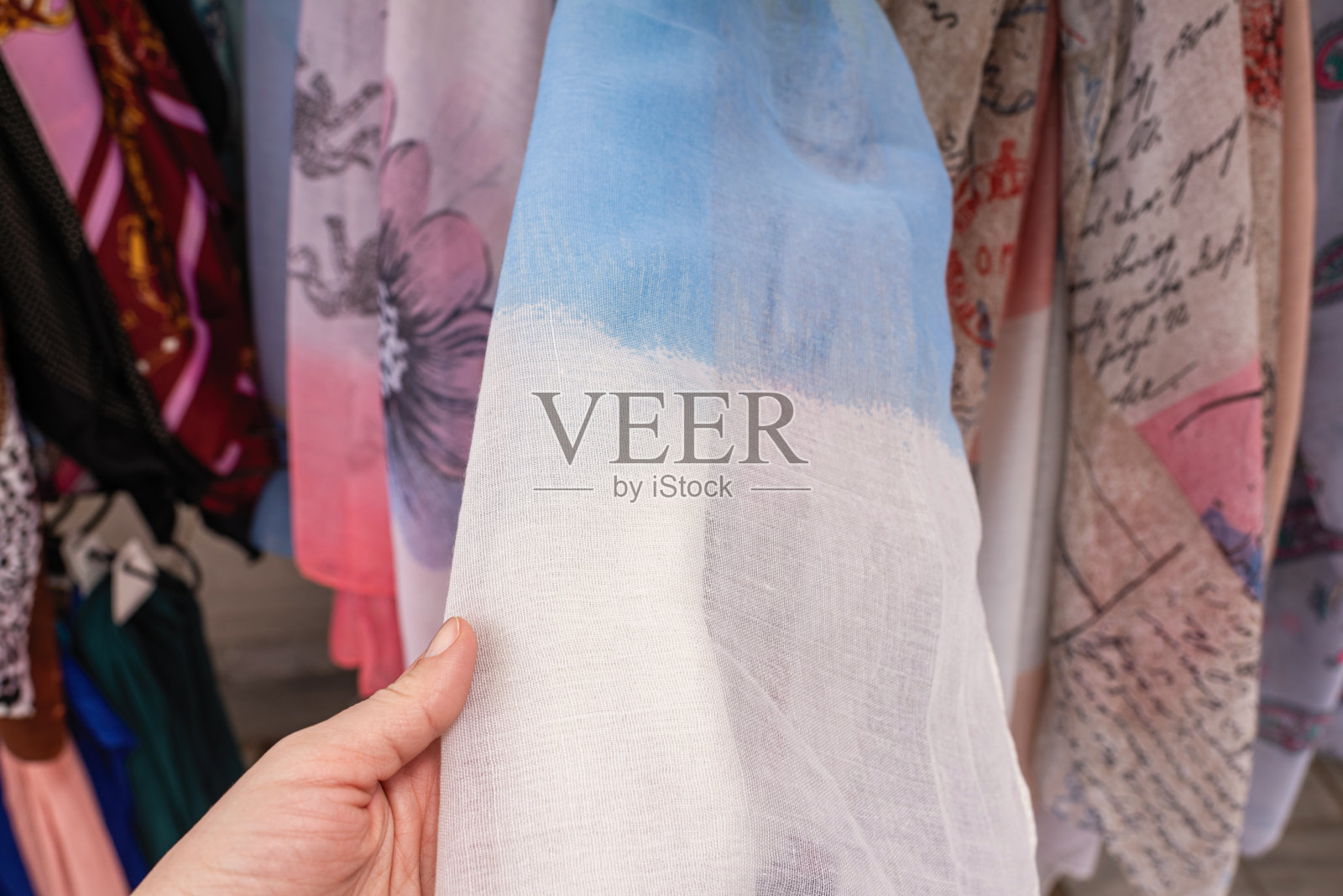 在旅游纪念品商店挑选彩色围巾的穆斯林女游客照片摄影图片