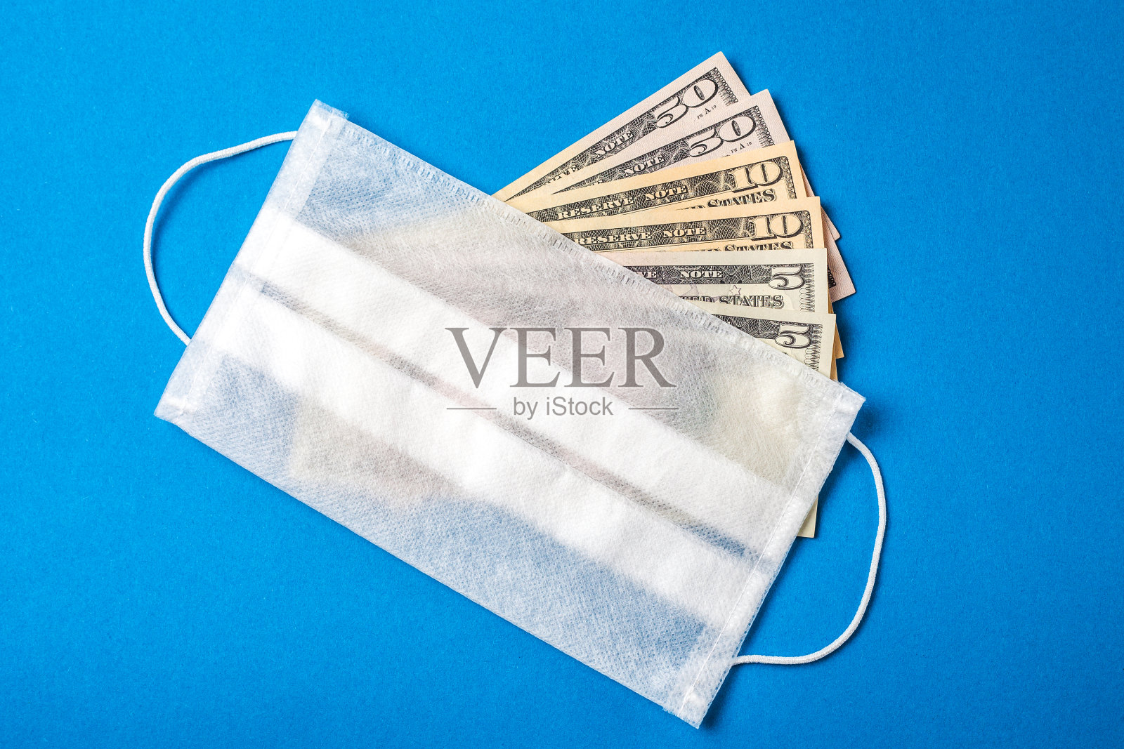 医用口罩和钱美国钱上的医疗面罩。金融危机的概念照片摄影图片