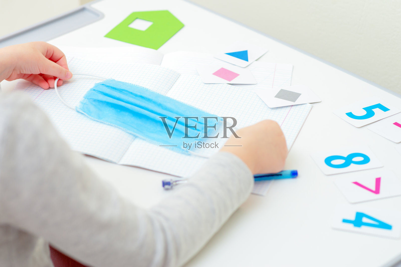 小女孩拿着医用口罩。照片摄影图片