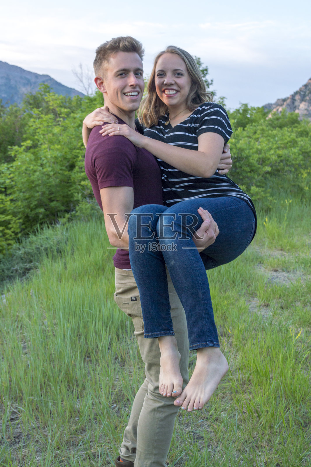 在瓦萨奇山脉的普罗沃峡谷附近，一对年轻的夫妇背着一个女人走在山间小道上照片摄影图片