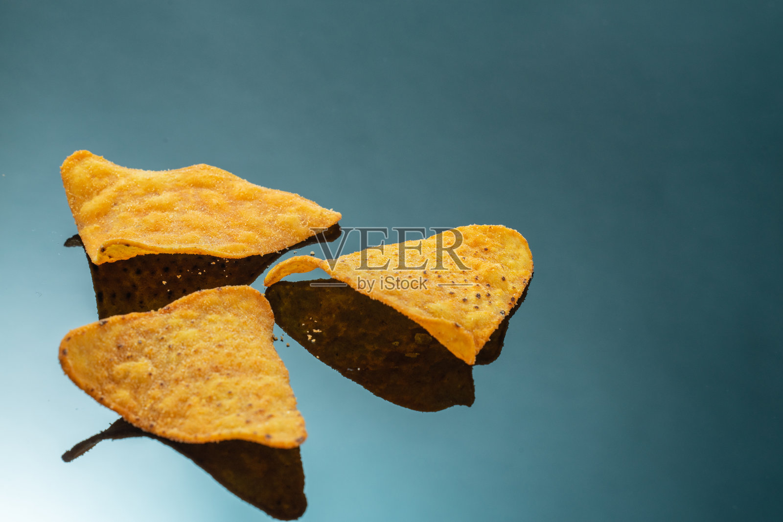 三角形玉米饼片在黑色镜面背景上照片摄影图片