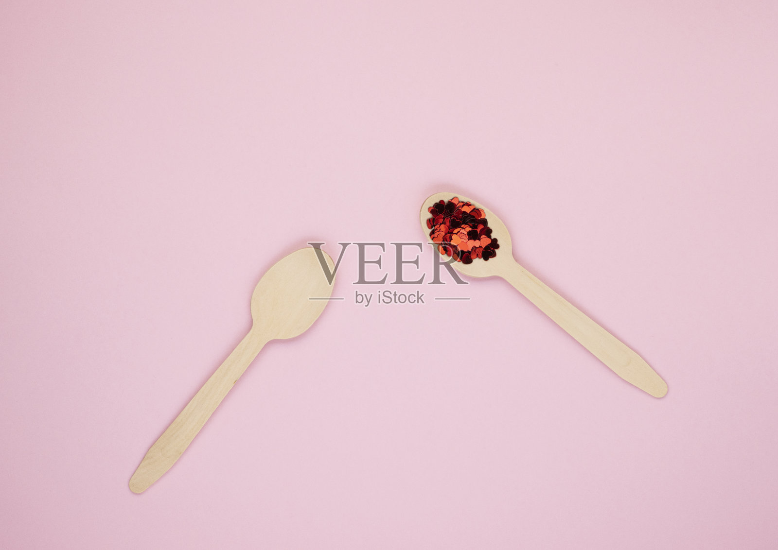 绿色环保的可生物降解的可降解的木质汤匙在柔软的粉红色背景照片摄影图片