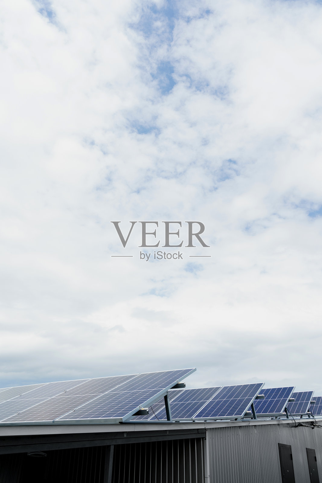 太阳能电池板在屋顶上垂直排列。家里免费用电。地球的可持续性。绿色能源。太阳能电池发电厂业务。生态清洁能源。地面上的蓝色面板照片摄影图片