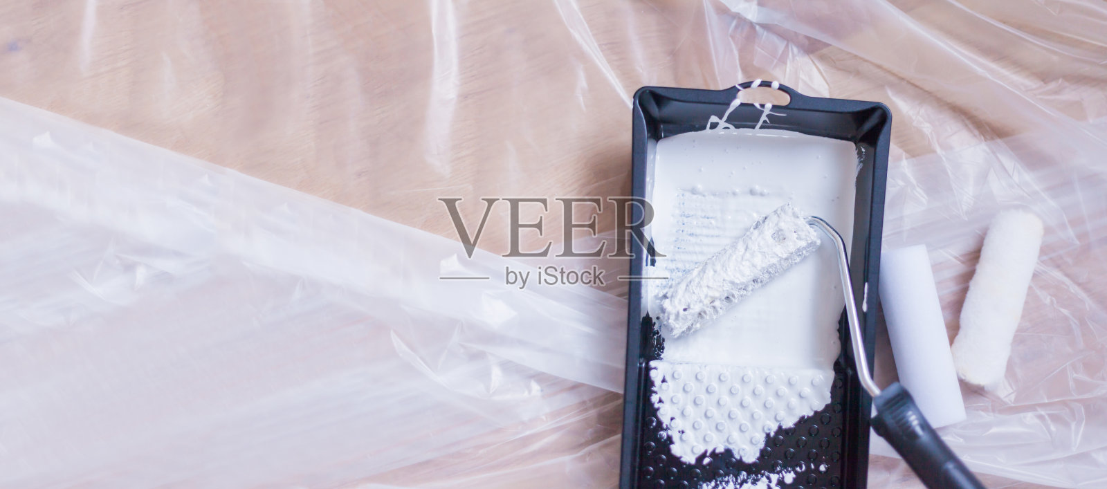 小油漆滚筒上的新鲜油漆躺在油漆工的箔上滴盘工艺品自己做照片摄影图片