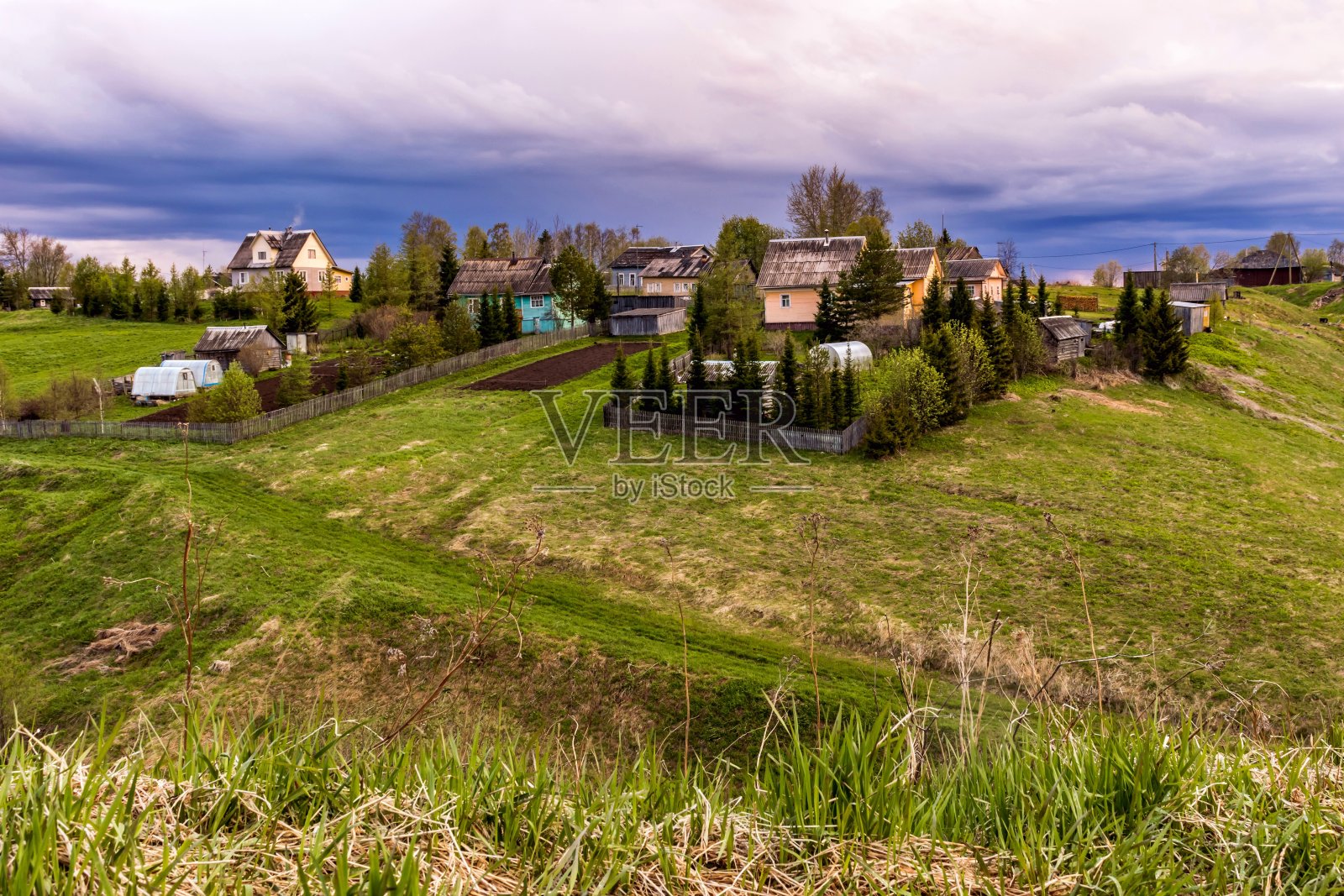 阴天背景下一座美丽的小山上的村庄照片摄影图片