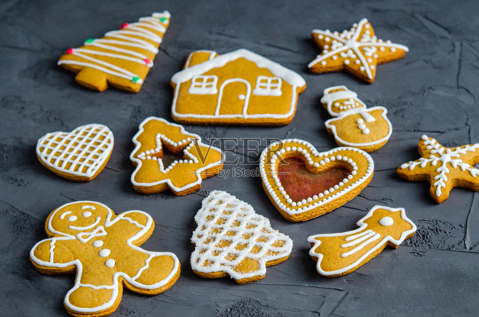 圣诞姜饼与白色糖霜涂在黑暗的背景。照片摄影图片