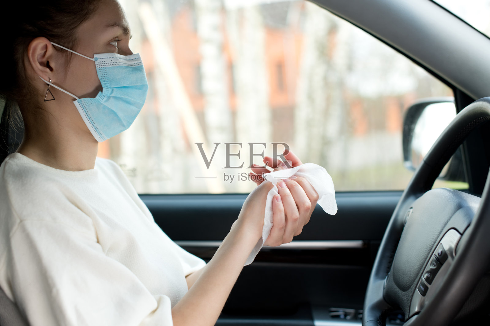 一名年轻女子在车里用消毒液擦手照片摄影图片