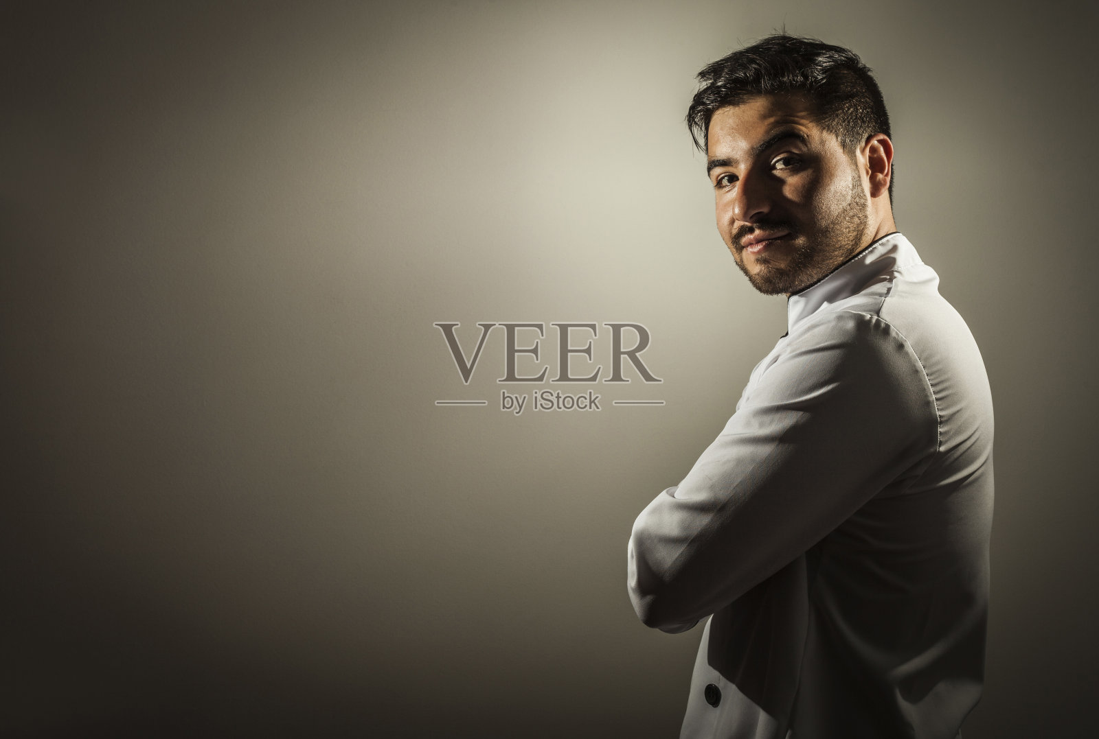 帅气的厨师在镜头前双臂交叉微微微笑的肖像照片摄影图片