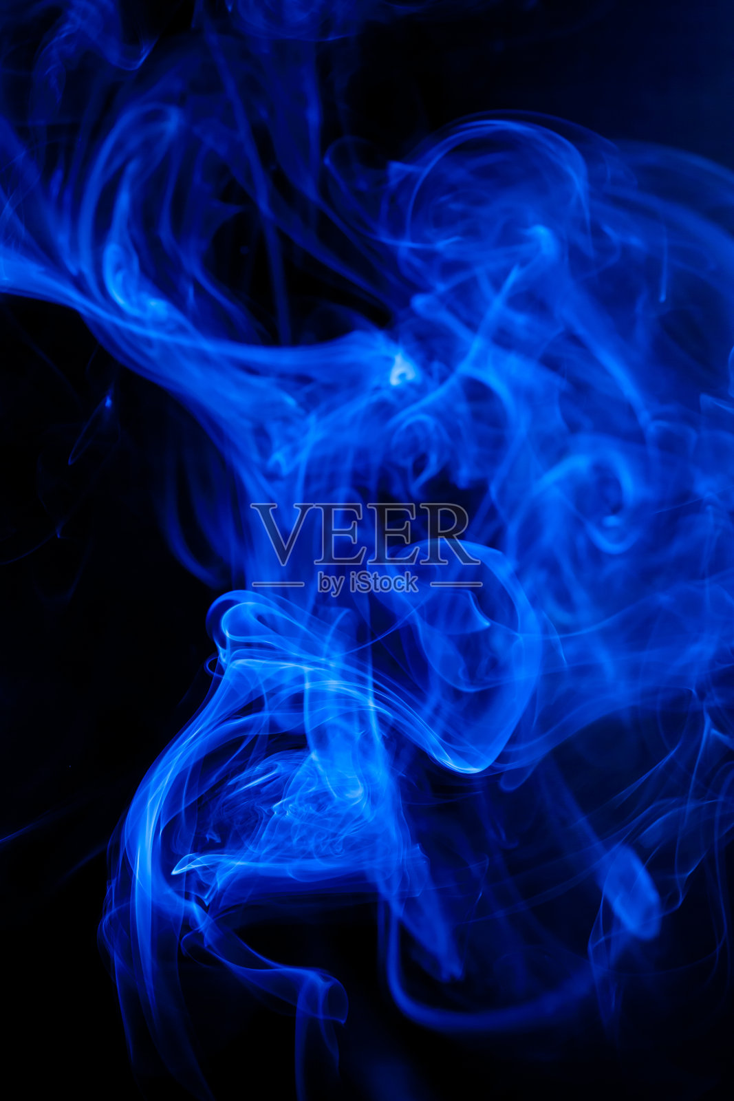 黑色背景上的蓝色烟雾运动。照片摄影图片