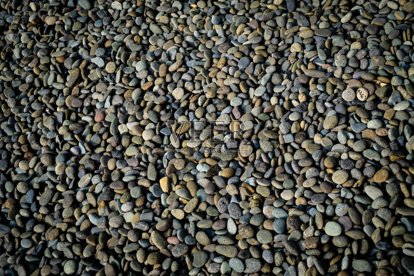 砾石的背景，有很多不同形状和颜色的砾石在地板上。纹理背景照片摄影图片
