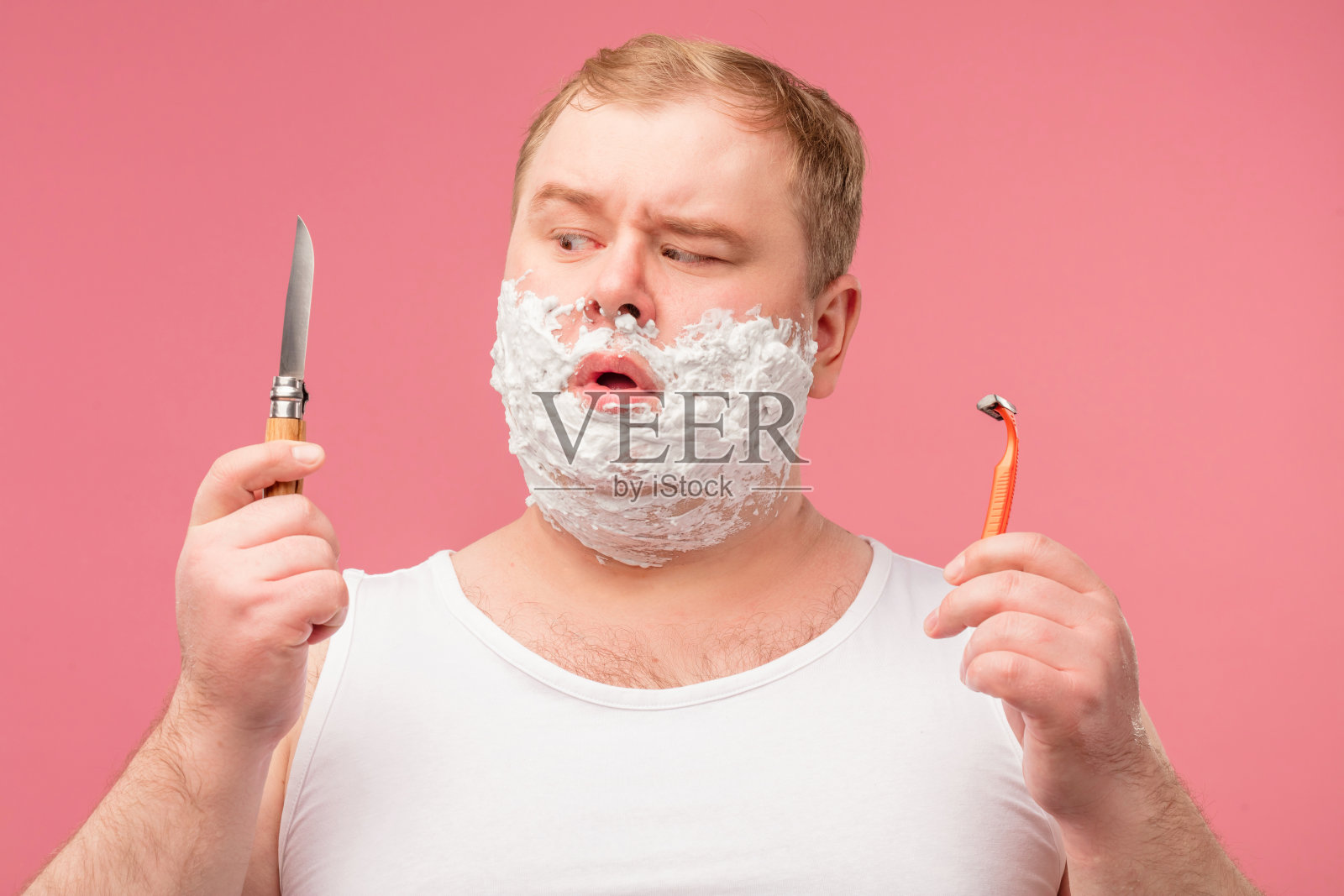 早晨的男人脸上有泡沫，脸上有悲伤的不高兴的表情，厌倦了剃须照片摄影图片