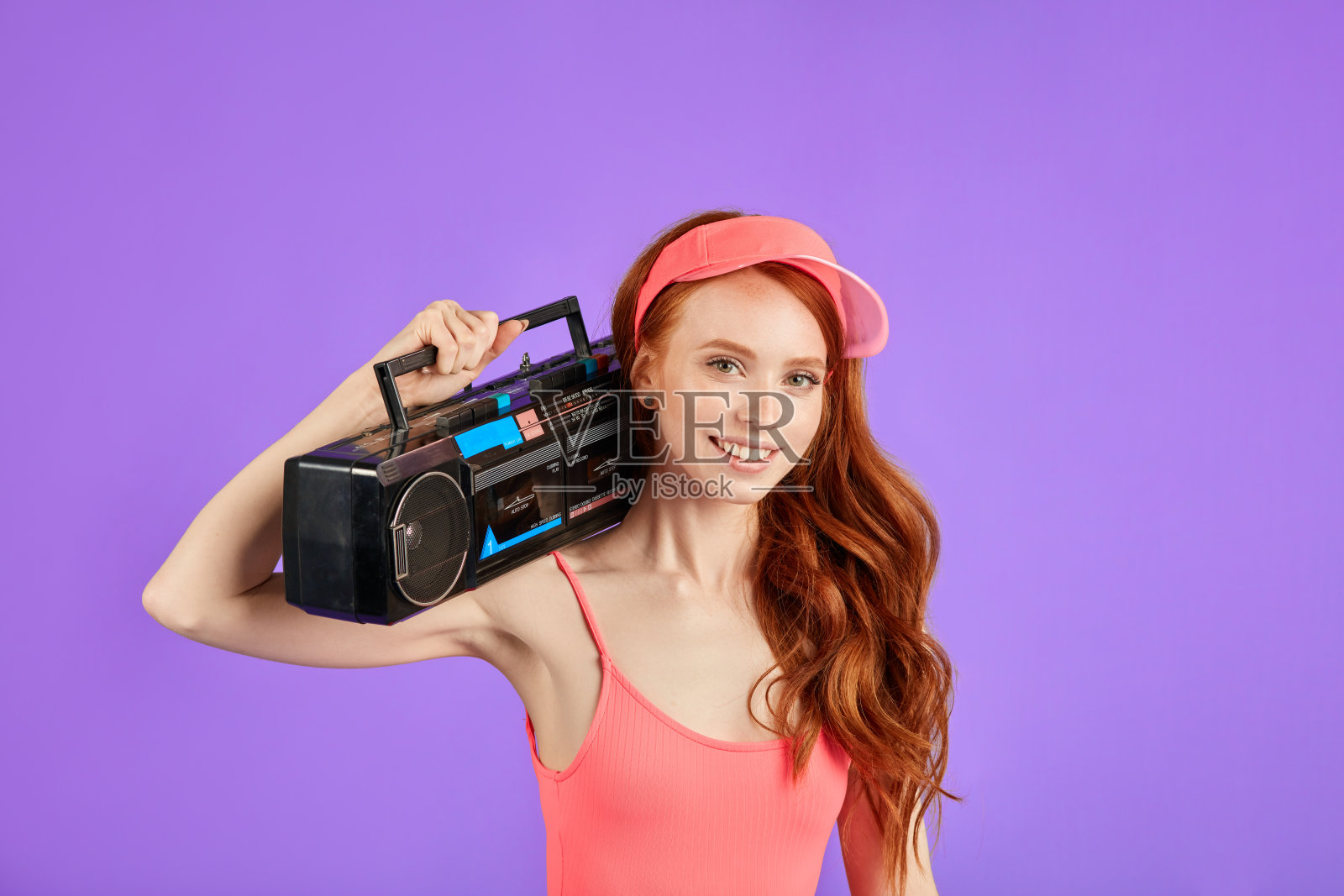 近距离拍摄的红发年轻女子与磁带播放机在她的肩膀上照片摄影图片