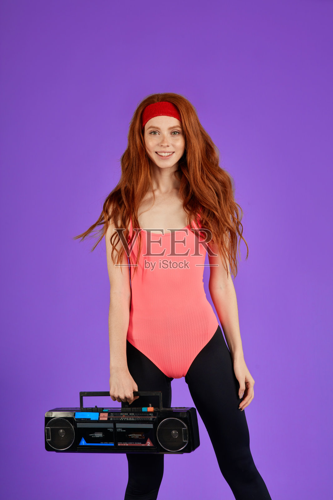 放松的塑形教练与强壮的肌肉和曲线，持有便携式音频播放器照片摄影图片