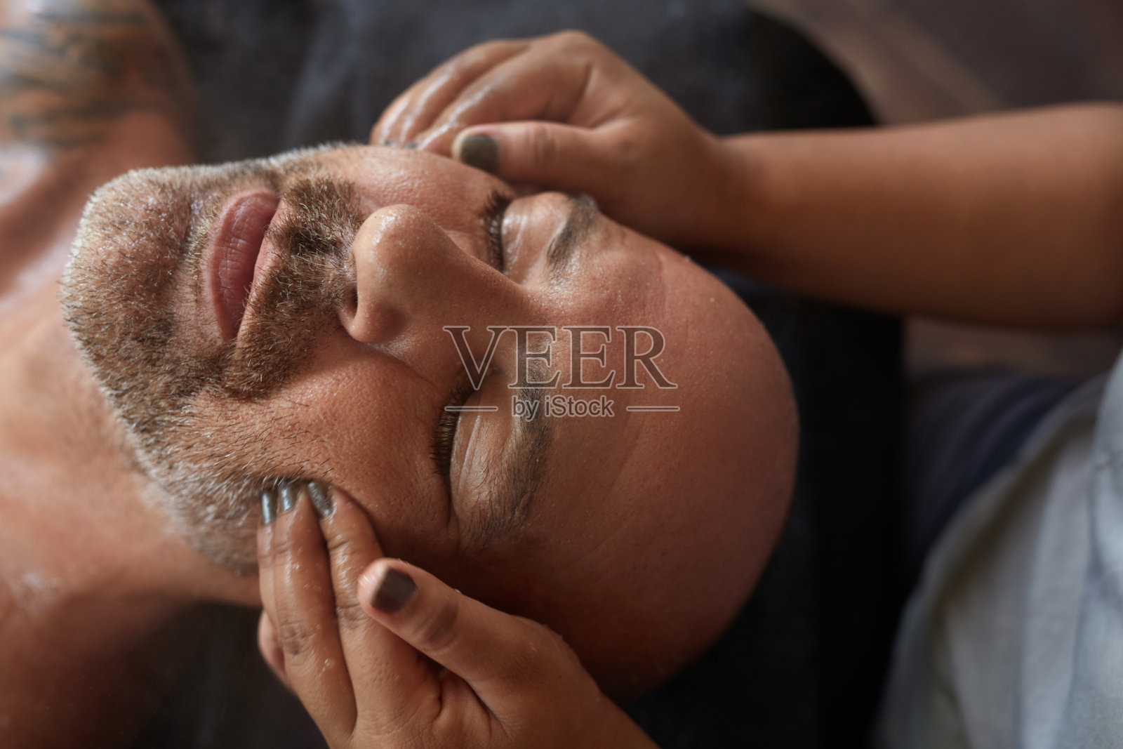 水疗面部按摩。皮肤护理美容。放松男人在自然美容面部程序。返老还童疗法。照片摄影图片