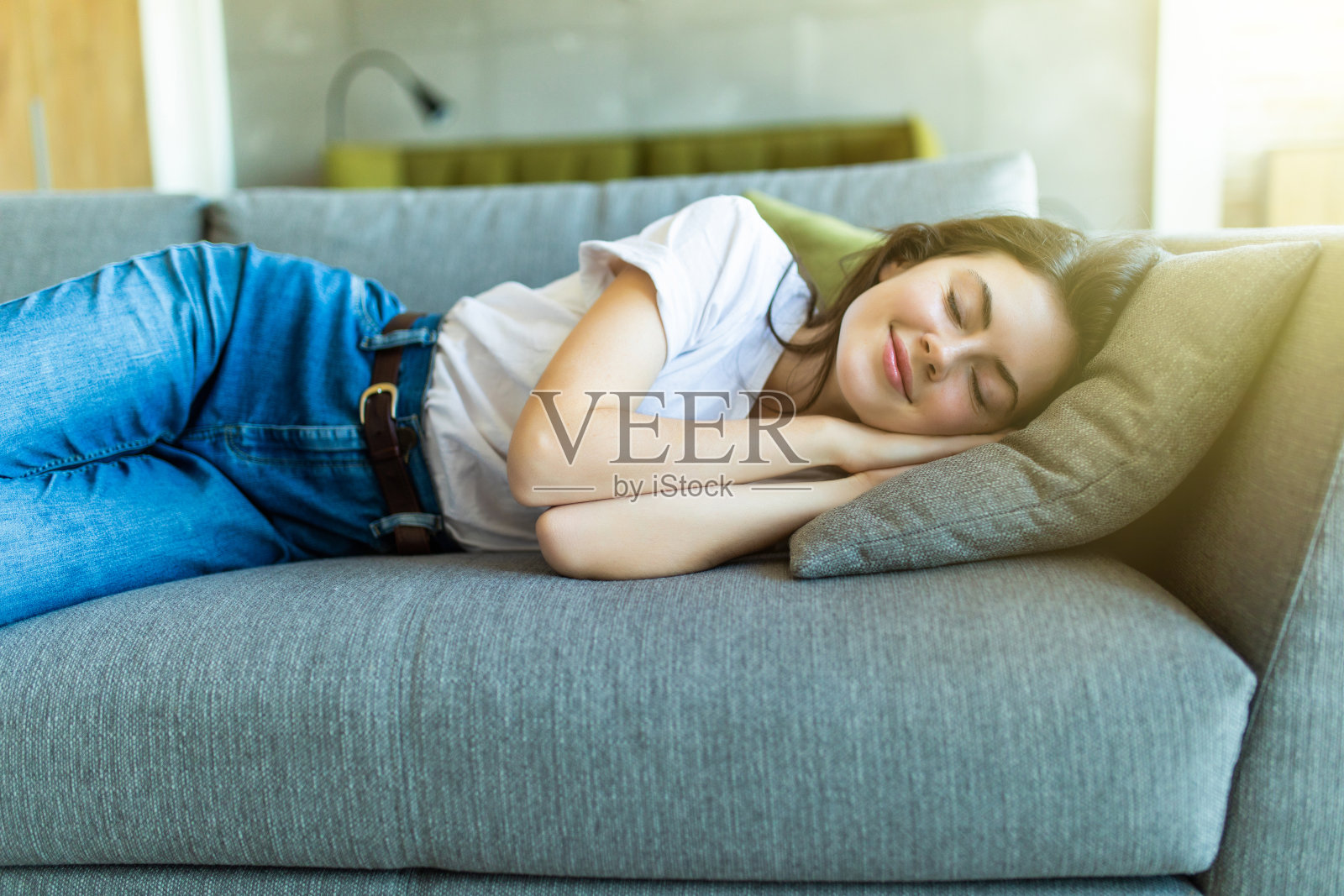 年轻漂亮的女孩睡在客厅的沙发上照片摄影图片