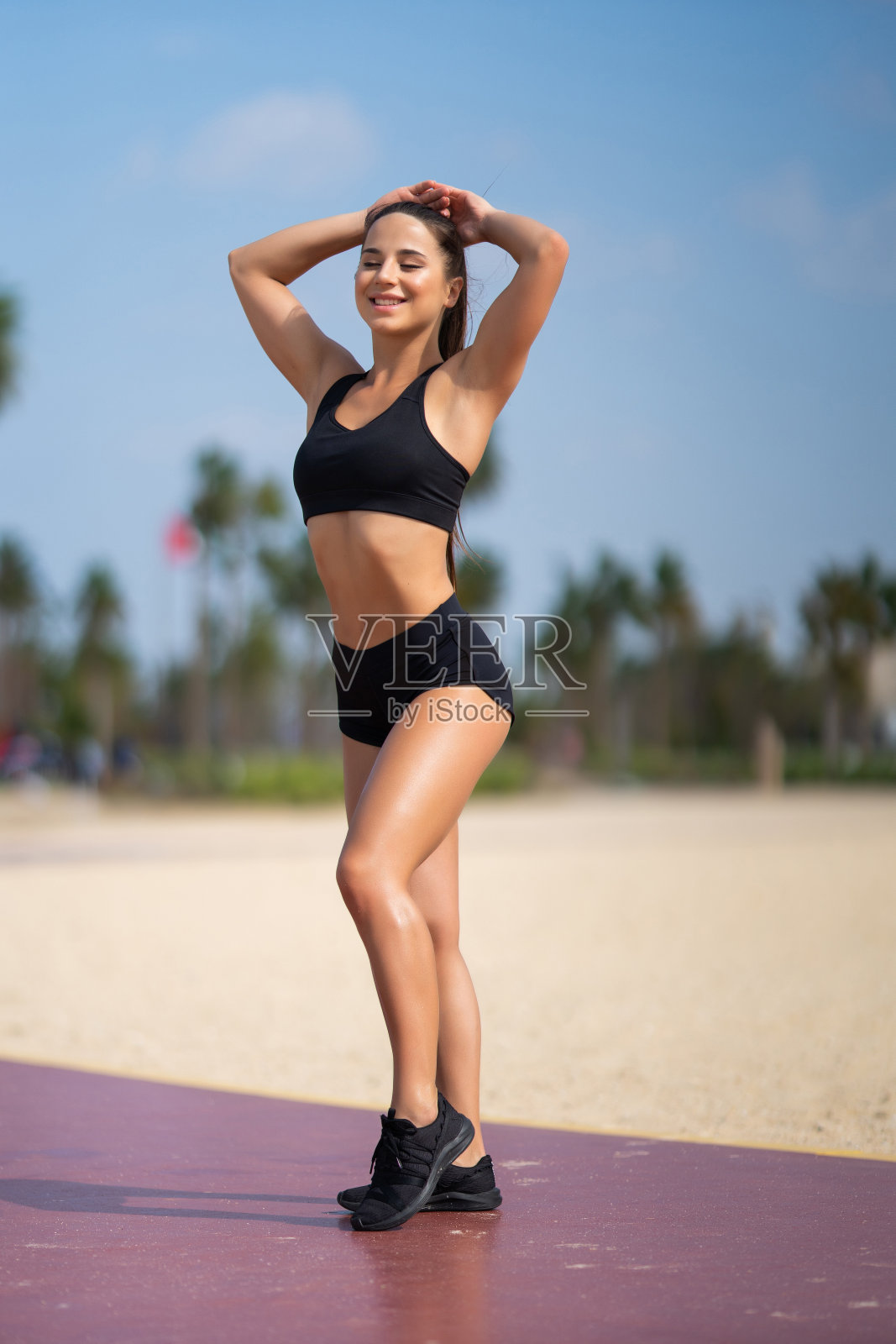 健康年轻女子扎马尾辫和准备海滩户外锻炼。照片摄影图片