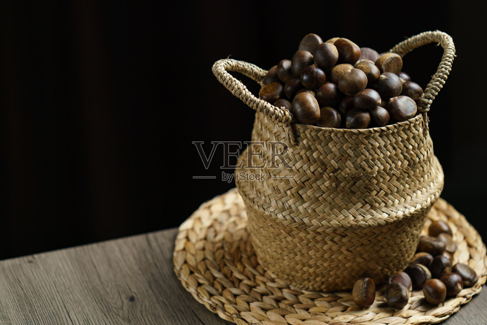 特写的柳条篮子满栗子。照片摄影图片